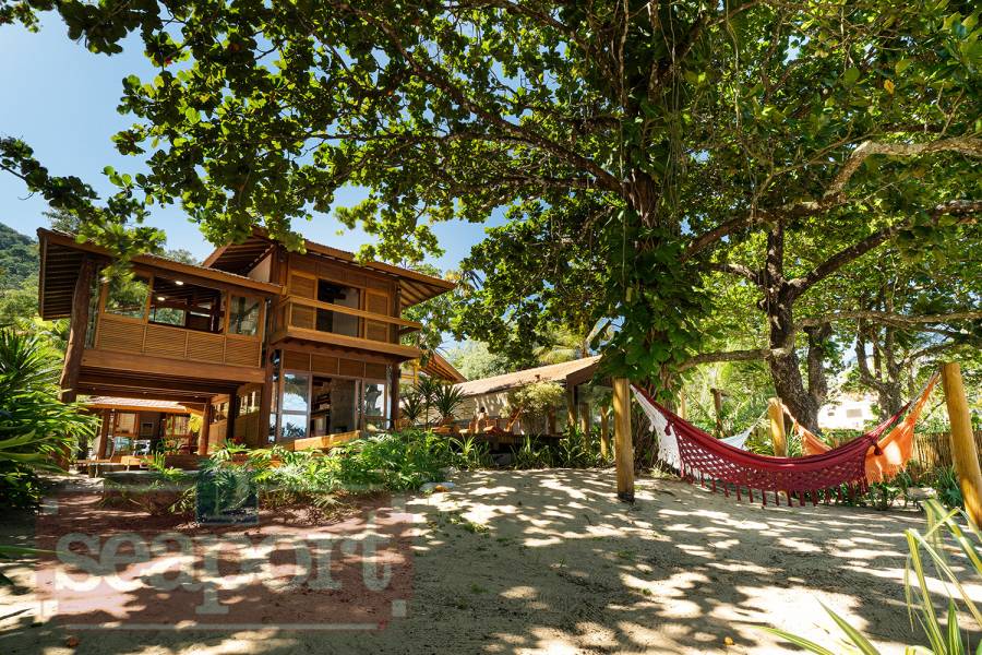 Fachada e amplo jardim frente ao mar 