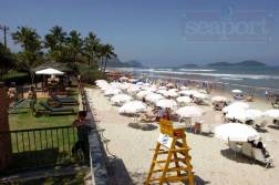 Serviço de praia do Condomínio com 4 cadeiras, 2 guarda-sol e mesinha